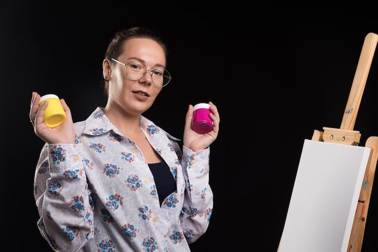 Painter working with brush and dark background